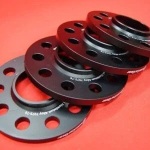 Stack of black aluminum wheel spacers.