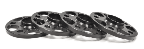 Black wheel spacers arranged in a stack.