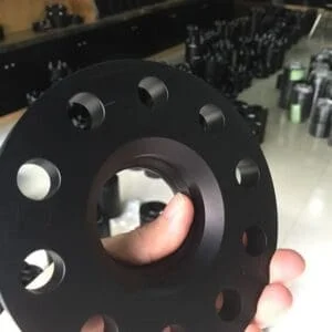 Black circular flange held in hand.