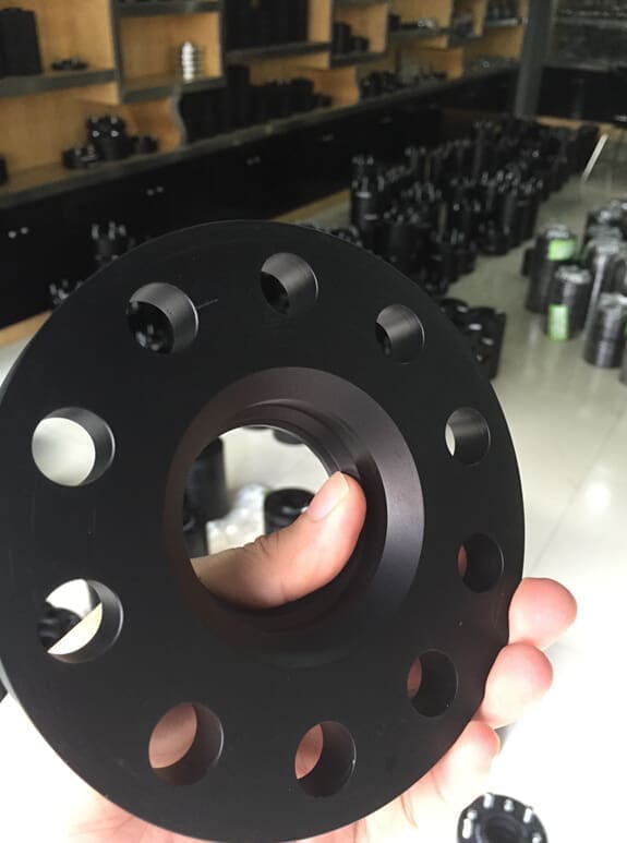 Black circular flange held in hand.