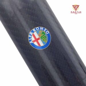 Alfa Romeo logo on carbon fiber surface.