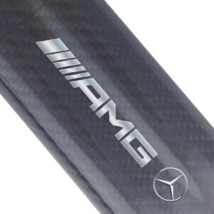 Close-up of an AMG carbon fiber car part with Mercedes-Benz logo.