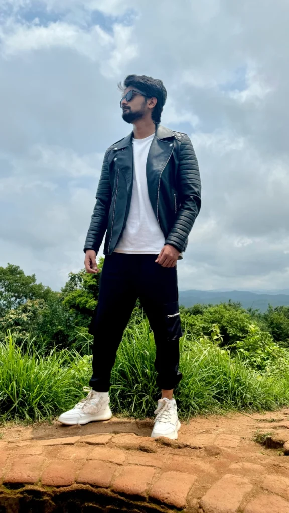 Amar Karthik standing on a hill with a black leather jacket