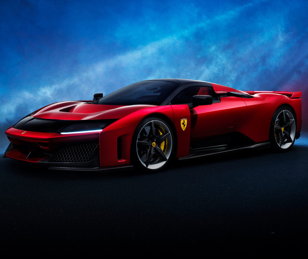 Sleek red Ferrari sports car against a dramatic blue sky background.